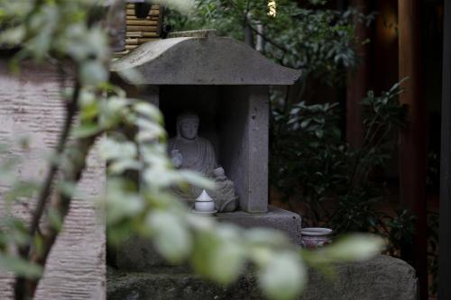 a statue of a man sitting in a bird house at Yufuin Souan Kosumosu in Yufuin