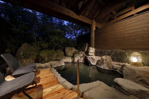 a pool of water with a chair on a wooden deck at Yufuin Souan Kosumosu in Yufuin