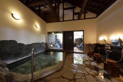 einen Pool in der Mitte eines Wohnzimmers mit Sofa in der Unterkunft Yufuin Souan Kosumosu in Yufu