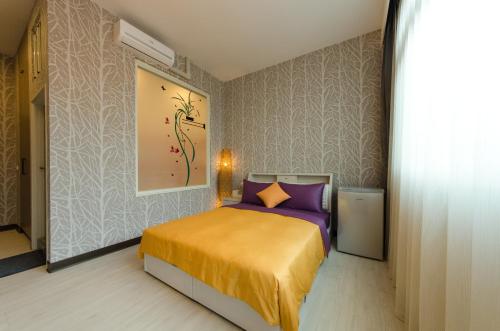 a bedroom with a bed and a painting on the wall at T. T. House in Hengchun