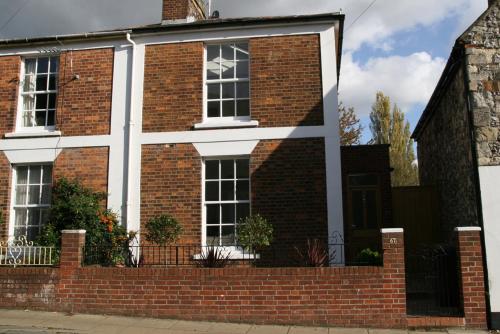a red brick house with a brick wall at Just a B in Winchester