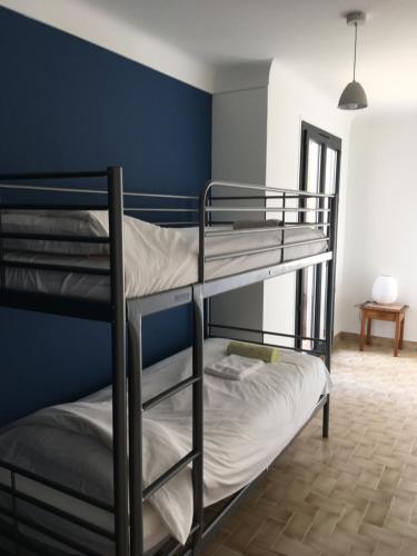 Ce lit se trouve dans un dortoir doté de 2 lits superposés et d'un mur bleu. dans l'établissement Villa Eugénie, à Saint-Martin-du-Var