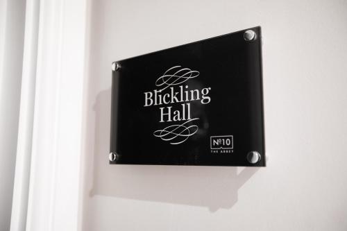 a black sign on a wall with the wordsblocking hall at Apartments at Number 10 The Abbey in Norwich