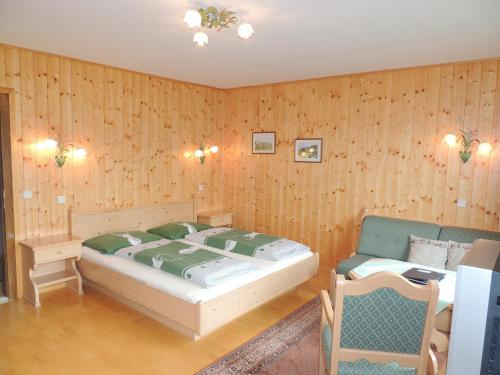 a bedroom with a bed and a table and a chair at Landhaus Santner - Örglwirt's Ferienwelt in Mariapfarr