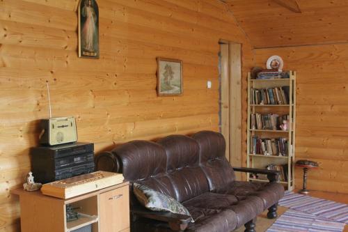a living room with a leather couch and a book shelf at Friendly House in Kolomyya