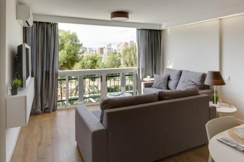 a living room with a couch and a large window at Apartamento Santa Barbara I in Alicante