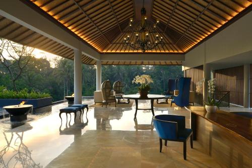 a patio with a table and chairs and a chandelier at Samsara Ubud in Ubud