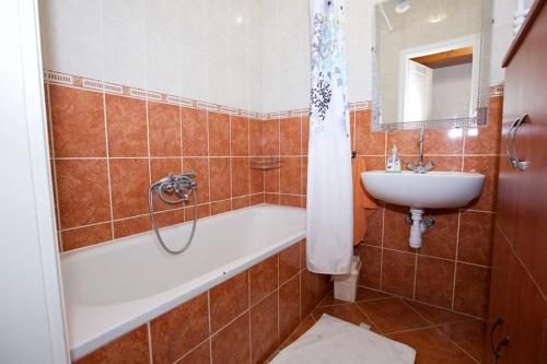 ein Badezimmer mit einer Badewanne und einem Waschbecken in der Unterkunft Zoli Apartmanok-Anita Kölcsey 34-36 in Hajdúszoboszló