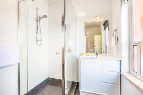 a white bathroom with a shower and a sink at Nightcap at Rose & Crown Hotel in Elizabeth