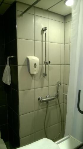 a bathroom with a shower with a soap dispenser at Hotel Uusikuu in Mikkeli