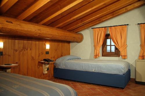 a bedroom with two beds and a window at Agriturismo Macesina in bedizzol