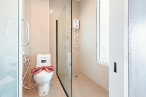 a bathroom with a toilet and a glass shower stall at Hansanan Hotel in Phitsanulok