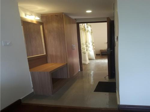 a hallway with a wooden cabinet and a door at Hotel Emerald Valley in Chail