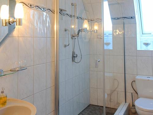 een badkamer met een douche, een toilet en een wastafel bij Apartmenthaus Hansen in Büsum