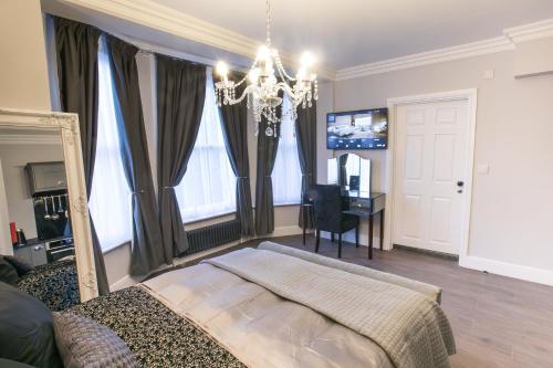 a bedroom with a bed and a mirror and a desk at Apartments at Number 10 The Abbey in Norwich