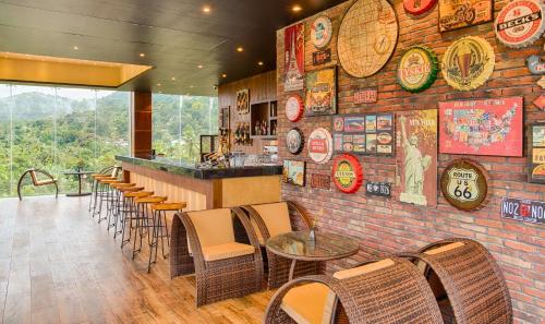 a restaurant with a brick wall with a bar and chairs at The Golden Crown Hotel in Kandy