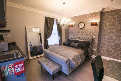 a bedroom with a bed and a mirror and a sink at Apartments at Number 10 The Abbey in Norwich