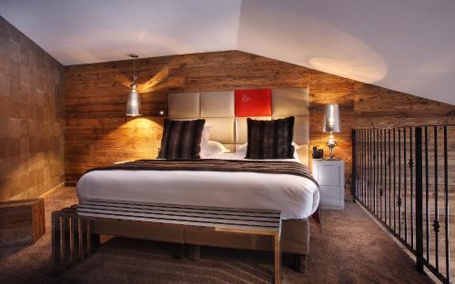 a bedroom with a large bed and a wooden wall at Hôtel Koh-I Nor by Les Etincelles in Val Thorens