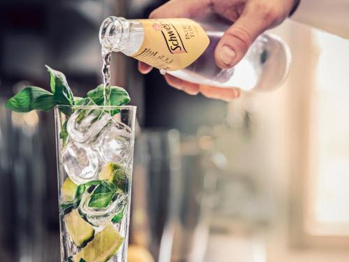a person pouring a bottle of champagne into a cocktail at Thoresta Herrgård in Bro