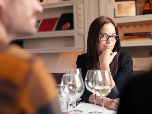 a woman sitting at a table with wine glasses at Thoresta Herrgård in Bro