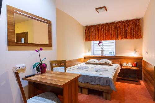 a bedroom with two beds and a table and a mirror at Hotel-24 in Płock