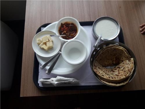 a tray with a plate of food on a table at Hotel Emerald Valley in Chail