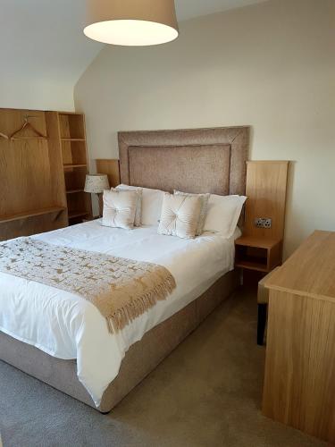a bedroom with a large bed with white sheets and pillows at Belfast House in Cookstown