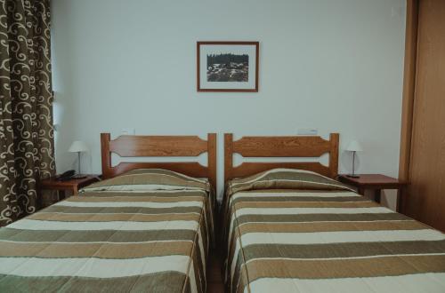 two beds sitting next to each other in a room at Hotel Albergaria Senhora do Espinheiro in Seia