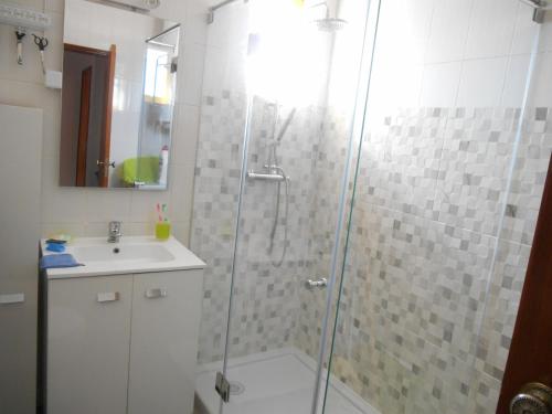 uma casa de banho com um chuveiro e um lavatório. em O Presidente em Portimão