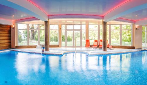 una piscina con sillas naranjas en una casa en Resort de Esperanto Sanatorium Uzdrowiskowe, en Duszniki-Zdrój