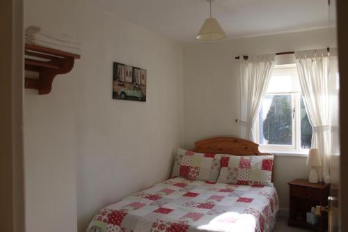 a bedroom with a bed with a quilt and a window at The Bridges Bed and Breakfast in Donegal