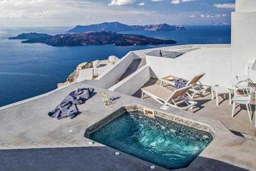 a pool of water with a surfboard on top of it at Villa Irini Fira - Adults Only in Fira