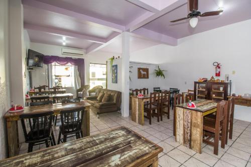 a living room with tables and chairs and a couch at Hotel Engenho in Penha