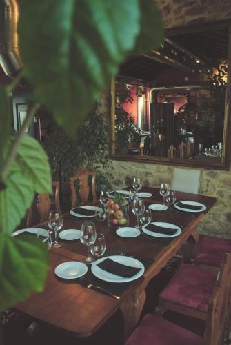 a wooden table with plates and wine glasses on it at El Lacayo de Sestiello in Grado