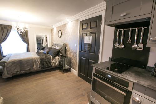 a bedroom with a bed and a flat screen tv at Apartments at Number 10 The Abbey in Norwich