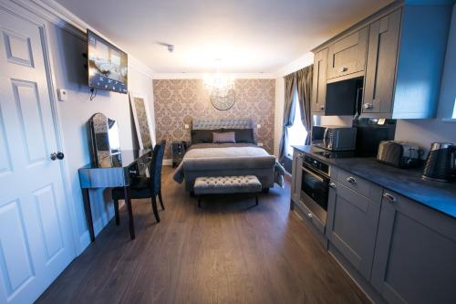 a small room with a bed and a kitchen and a room with a bed gmaxwell at Apartments at Number 10 The Abbey in Norwich