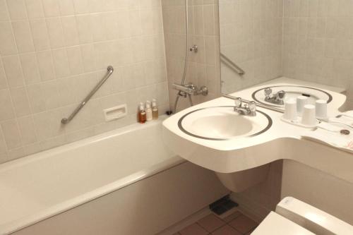 a bathroom with a sink and a toilet and a tub and a sink at OMO7 Asahikawa by Hoshino Resorts in Asahikawa