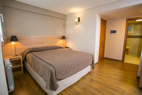 a bedroom with a large bed and a wooden floor at Hotel Ayres Del Nahuel in San Carlos de Bariloche
