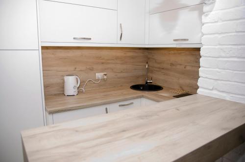 a kitchen with white cabinets and a sink at kameralny apartament in Olsztyn