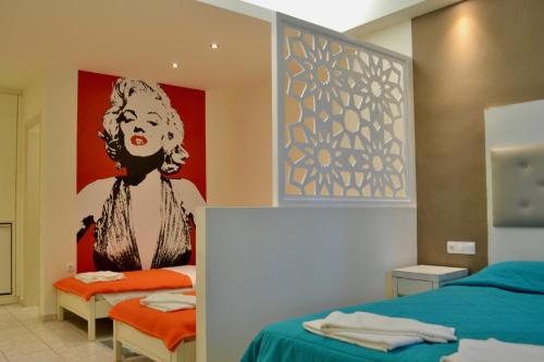 a room with two beds and a painting of a woman at Paloma Blanca in Dassia