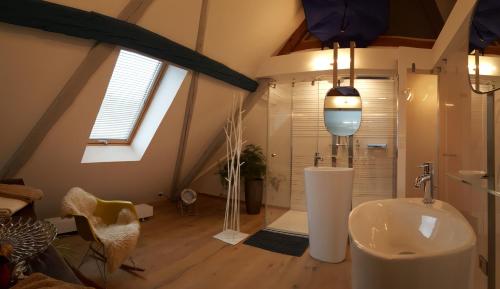 a bathroom with a sink and a shower in a attic at Le Chat Rouge Chambres d'Hôtes de Charme en Alsace in Orbey