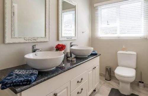 a bathroom with two sinks and a toilet and a mirror at Anna's Place in Cape Town