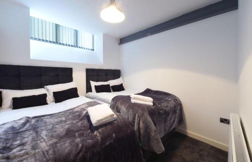 a bedroom with two beds and a radiator at Converted warehouse Slps 14 (38 A1) in Manchester