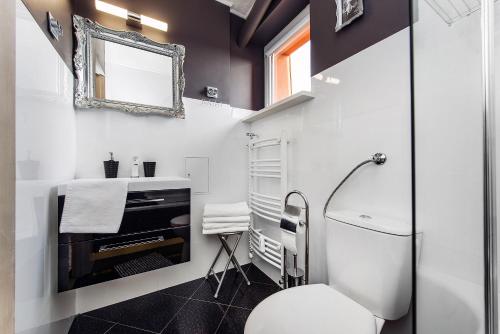 a bathroom with a white toilet and a mirror at Apartament Rodzinny in Kościelisko