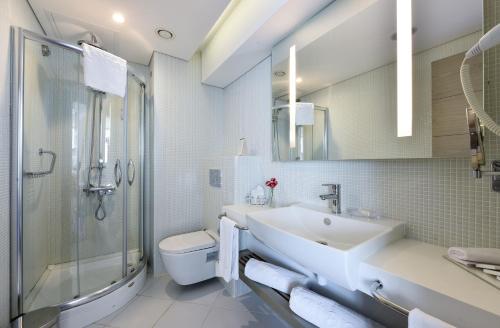 a bathroom with a sink and a shower and a toilet at Burgu Arjaan by Rotana Istanbul Asia in Istanbul