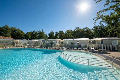 a large swimming pool at a apartment complex at Camping Les Chèvrefeuilles in Royan