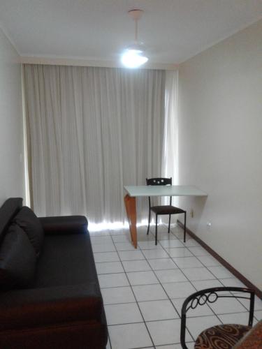 a living room with a couch and a table at Apart Quartier Latin in Vitória