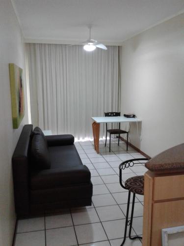 a living room with a couch and a table at Apart Quartier Latin in Vitória