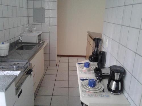 a small kitchen with a stove with cups on it at Apart Quartier Latin in Vitória