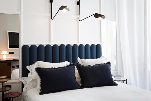 a bedroom with a blue headboard and a bed with pillows at One Shot Conde Torrejón in Seville
